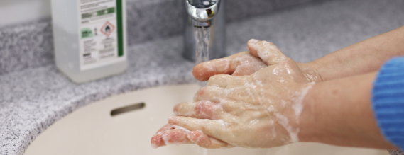 Foto: Nærbillede af hænder, der bliver vasket i en håndvask.
